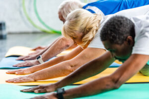 A diverse group of active seniors enjoy a yoga class together.
